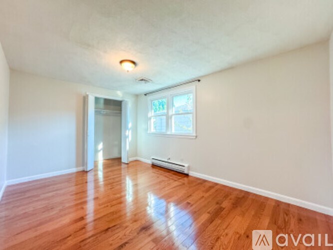 A room with wooden flooring and a window.