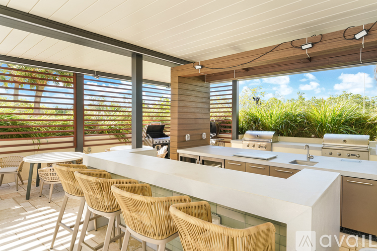 A kitchen with a white countertop and wicker chairs.