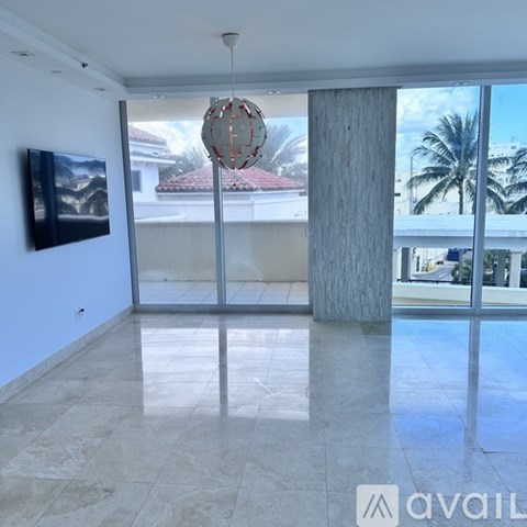 A modern living room with a television and a hanging light fixture.