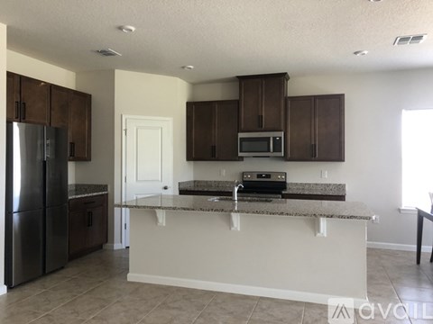A kitchen with brown cabinets and a granite countertop.