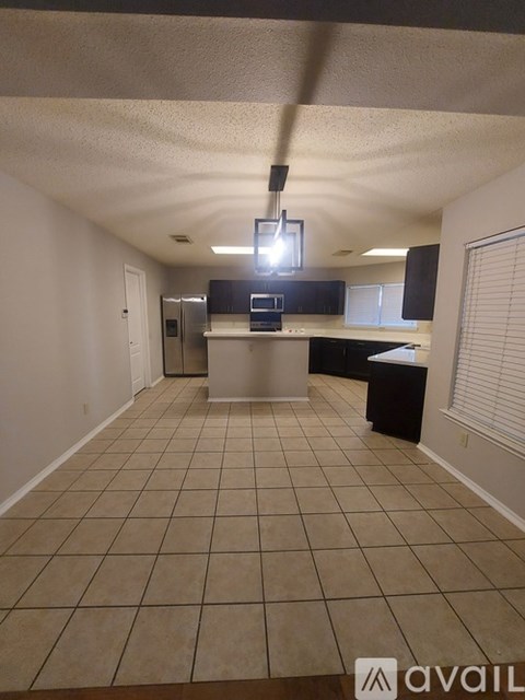 A kitchen area with a refrigerator, microwave, and oven.