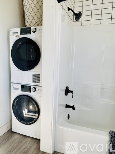 A white washing machine and dryer in a small bathroom.