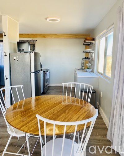 A kitchen with a table and chairs.