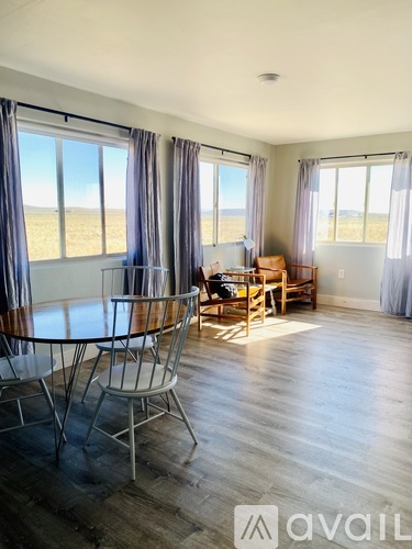 A living room with a large table and chairs.