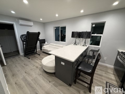 A modern kitchen with a white countertop and wooden flooring.
