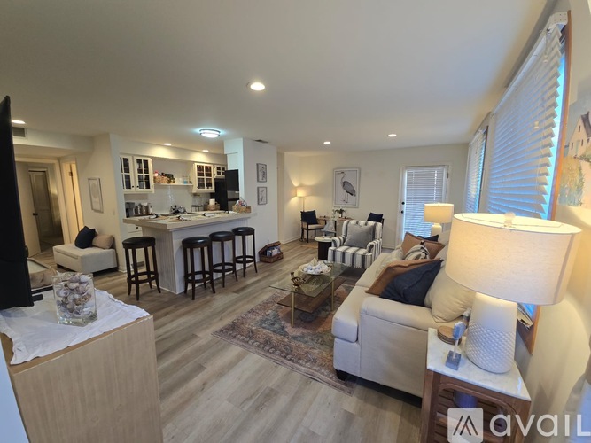 A living room with a couch, a coffee table, and a television.