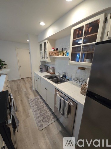 A kitchen with a black fridge and a white counter top.
