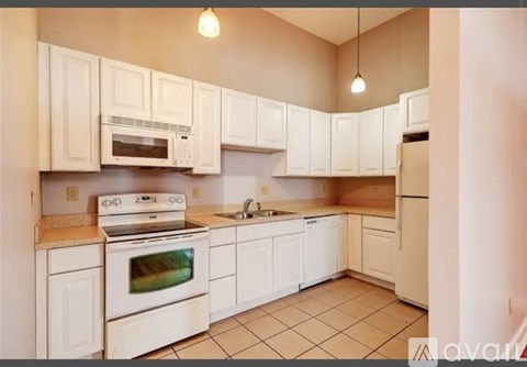 A kitchen with white cabinets and appliances.