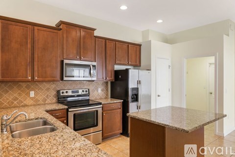 A kitchen with brown cabinets and a granite countertop.