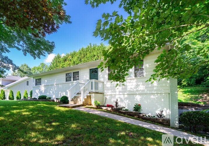A white house with a green lawn in front.