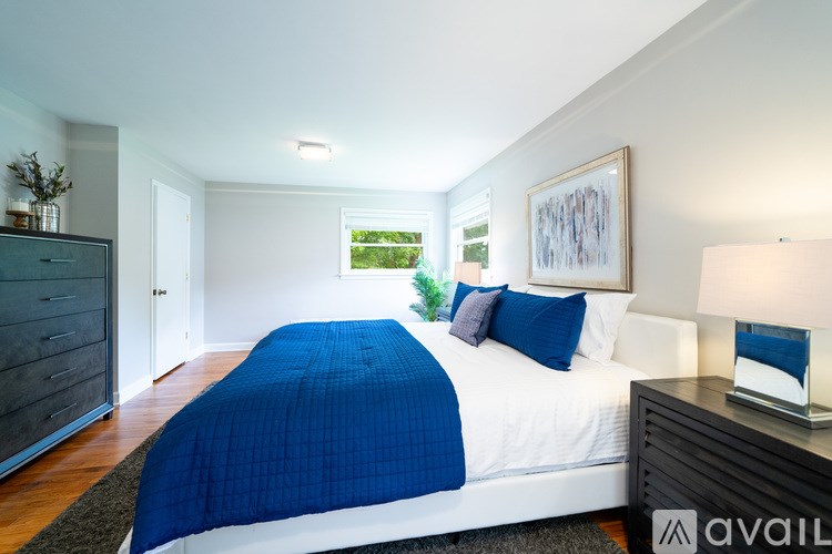 A bedroom with a bed, nightstand, and lamp.