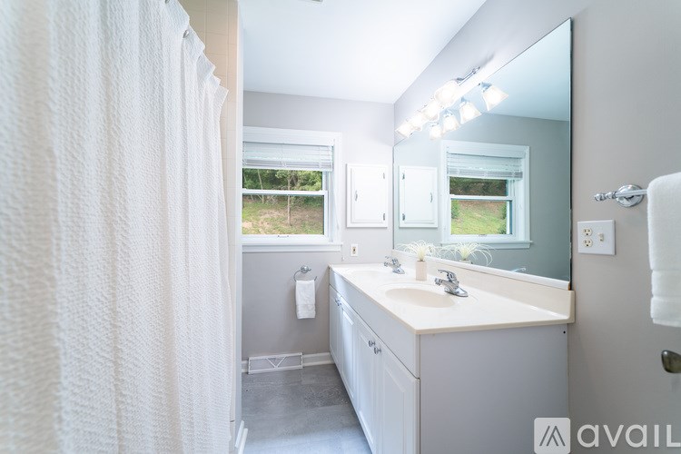 A bathroom with a white sink and a large mirror.