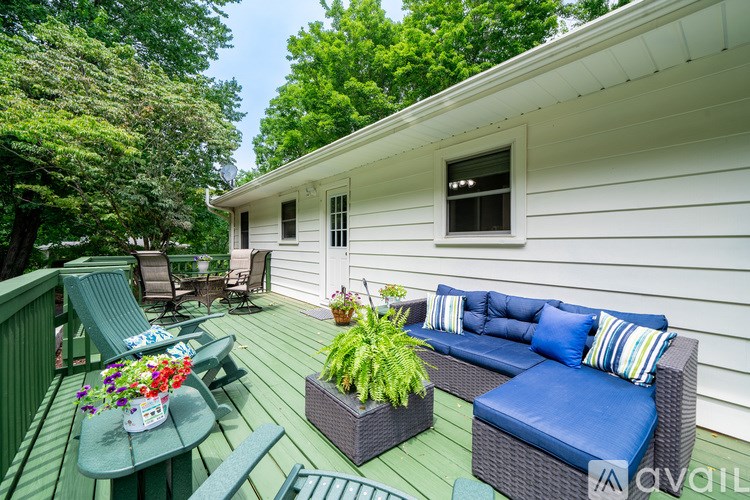 A white house with a blue couch and a green table.