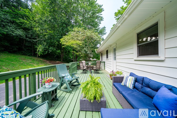 A patio with a couch, chairs, and a table with flowers is shown.
