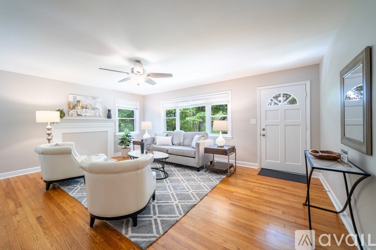 A living room with a white sofa and a round white table.