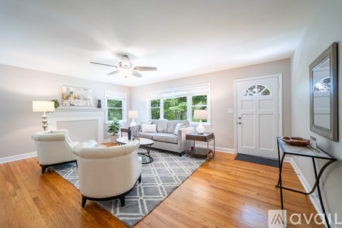 A living room with a white sofa and a round white table.