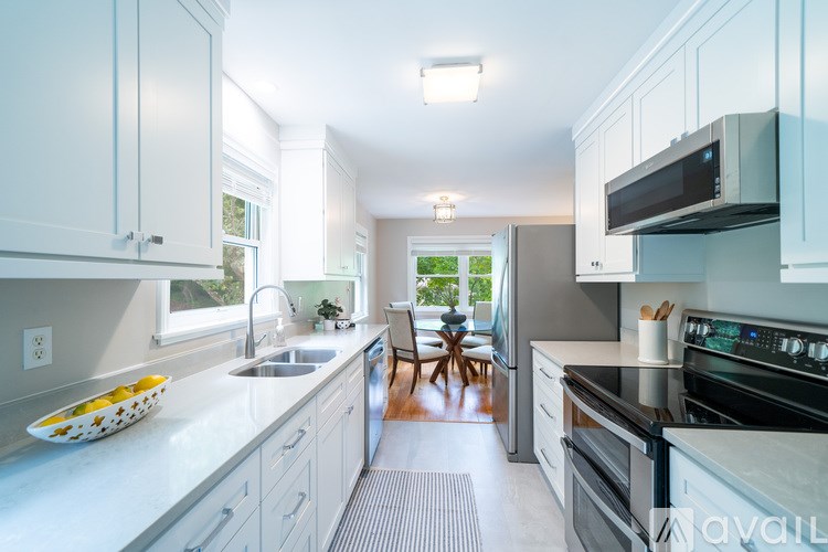 A modern kitchen with white cabinets and a black stove top oven.