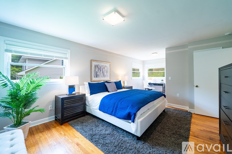 A bedroom with a bed, nightstand, and lamp.