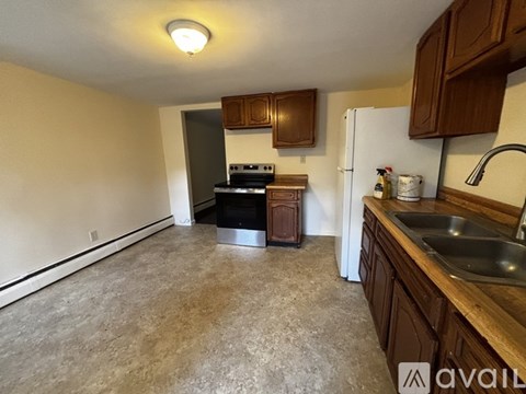 A kitchen with a stove, refrigerator, and sink.