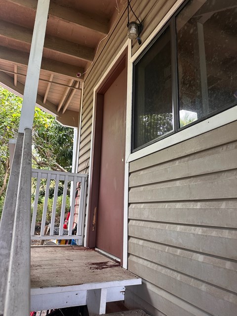 A white door is open to a porch.