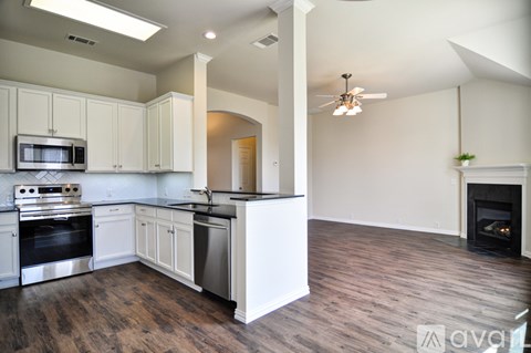 A kitchen with white cabinets and a wood floor.