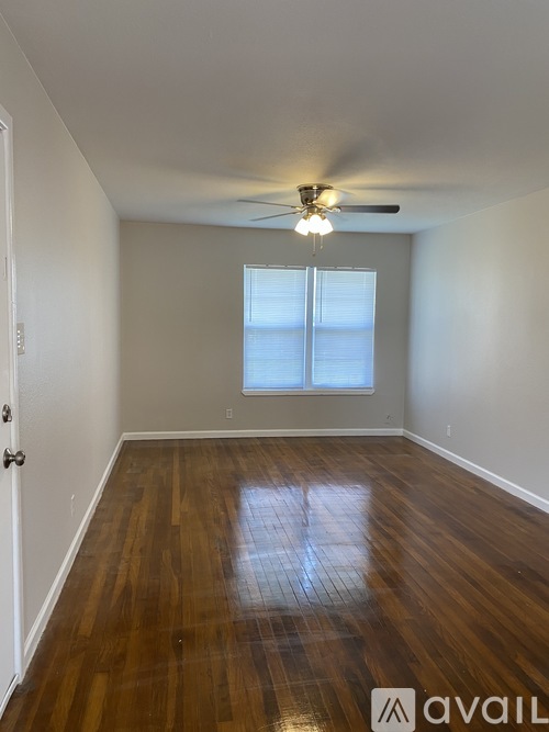A room with wooden floors and a ceiling fan.