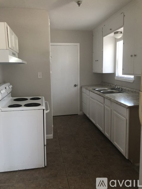 A kitchen with white appliances and cabinets.
