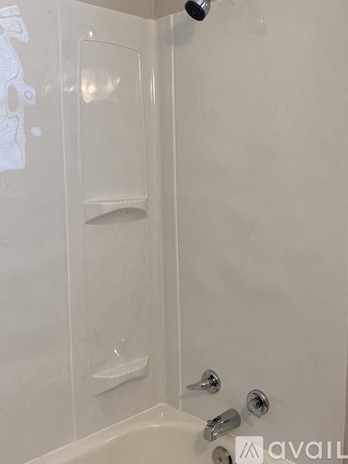 A white bathroom with a shower and a glass door.