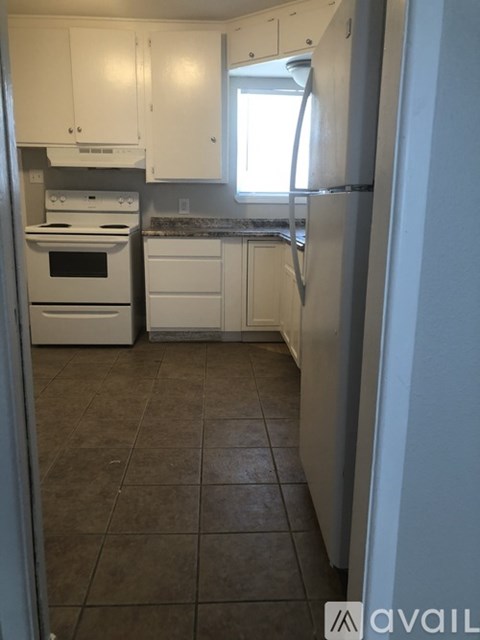 A kitchen with white appliances and cabinets.