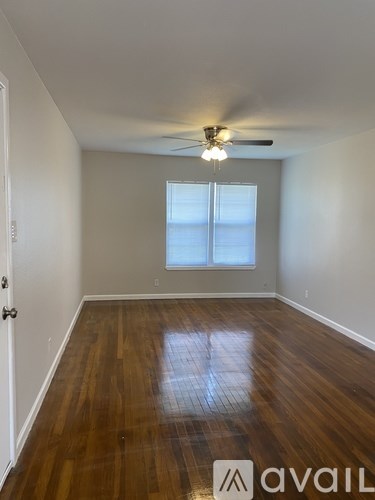 A room with wooden floors and a ceiling fan.