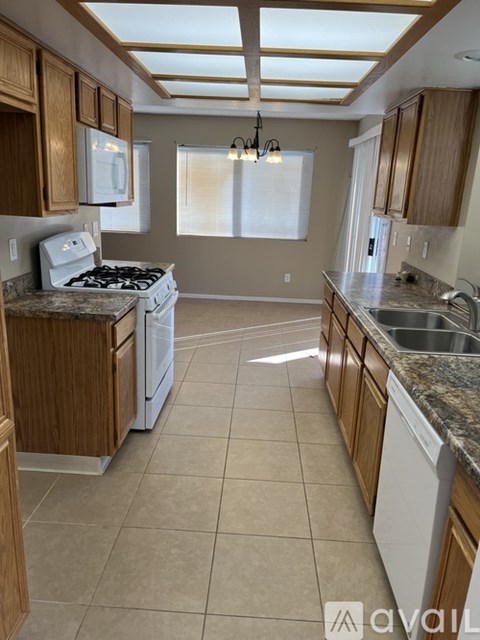 A kitchen with wooden cabinets and a white stove top oven.