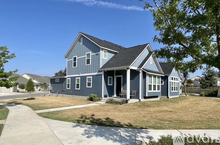 A blue house with a white trim and a black roof.