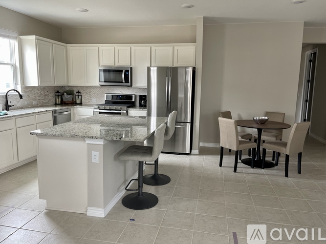 A kitchen with a granite countertop and a refrigerator.