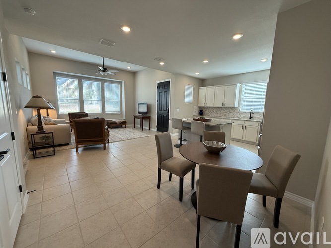 A spacious living room with a dining table set up with chairs.