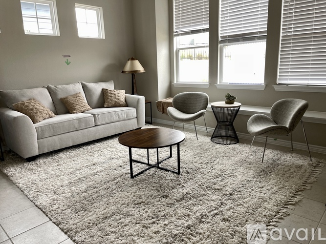 A living room with a couch, chairs, and a table.