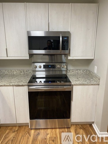 A kitchen with a stainless steel oven and microwave above it.