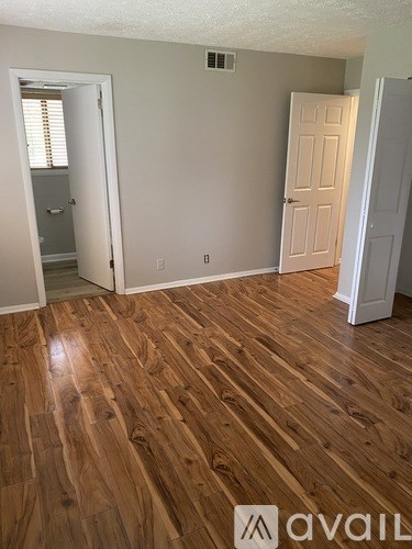 A room with wooden flooring and two doors.