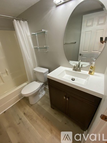 A bathroom with a toilet, sink, and mirror.