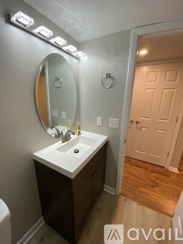 A bathroom with a sink, mirror, and lights.