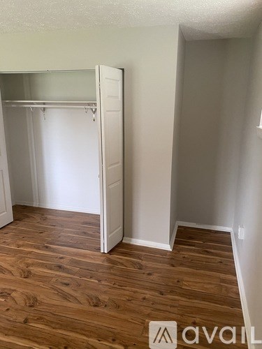 A room with a white closet and wooden floors.