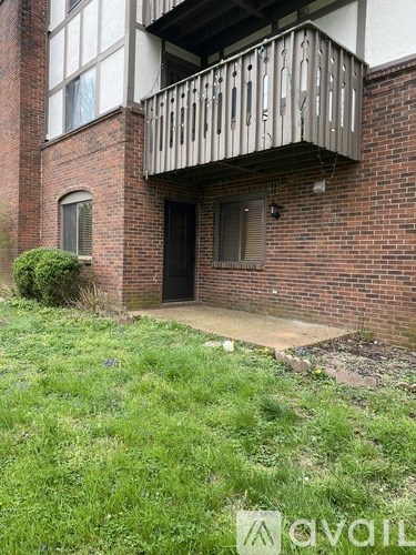 A balcony with a railing is on the second floor of a brick building.