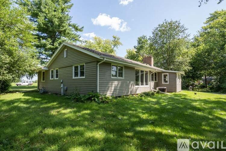 A house with a grey roof and a green lawn in front.