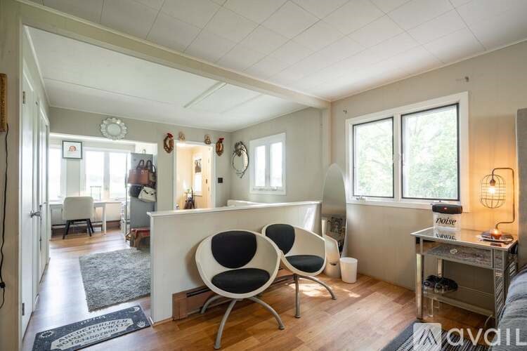 A living room with a white sofa and a black and white chair.