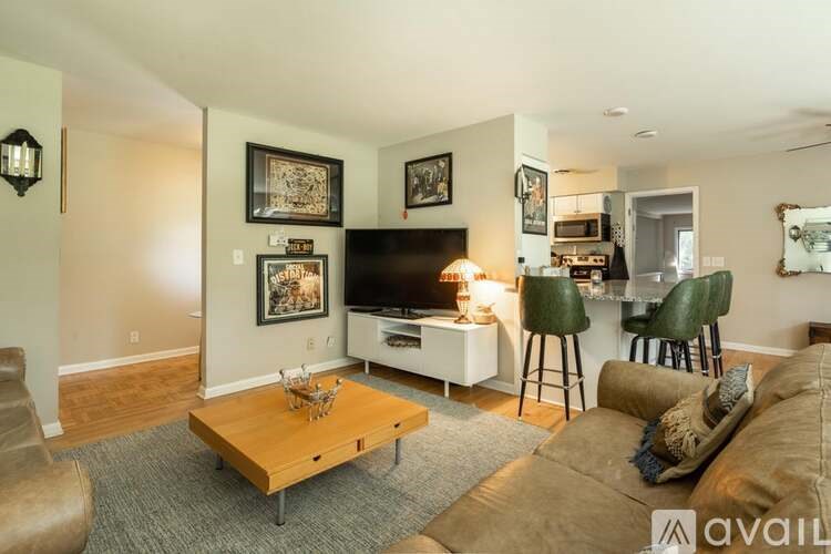 A living room with a brown couch, a coffee table, and a flat screen TV.
