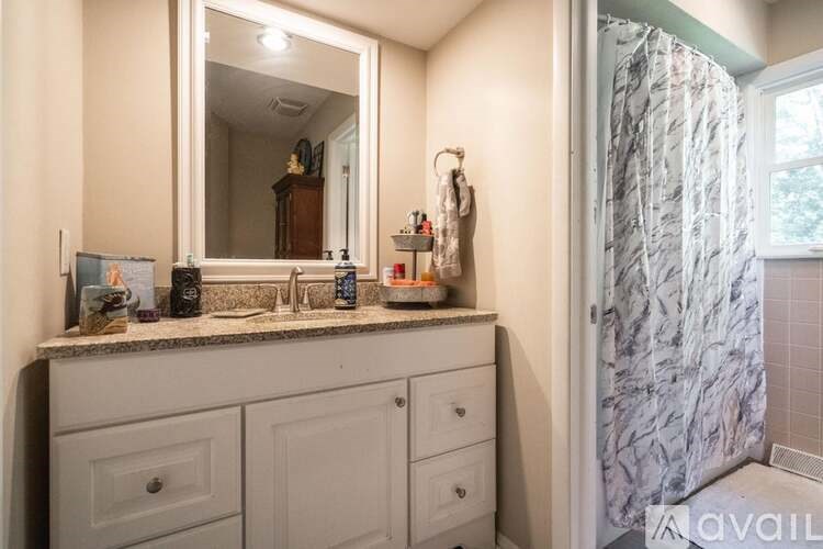A bathroom with a marble shower and a vanity with a mirror above it.