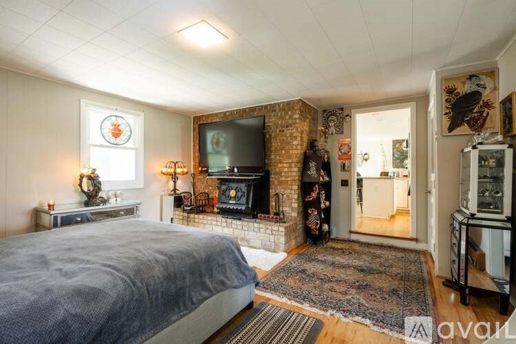 A bedroom with a large bed and a fireplace.