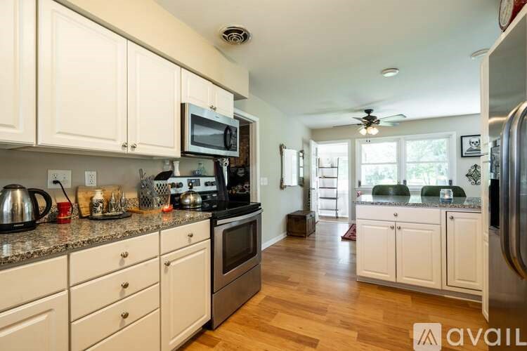 A kitchen with white cabinets and a black countertop.