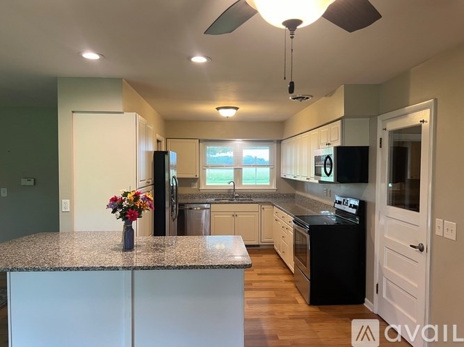 A kitchen with granite countertops and a black dishwasher.