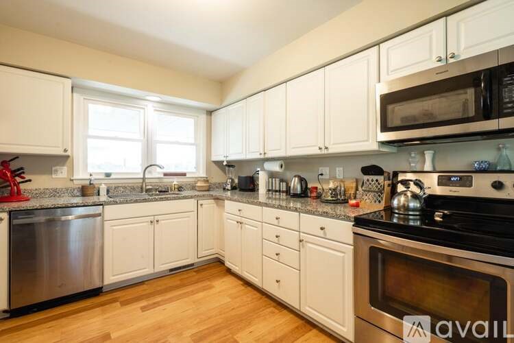 A kitchen with white cabinets and a wooden floor.