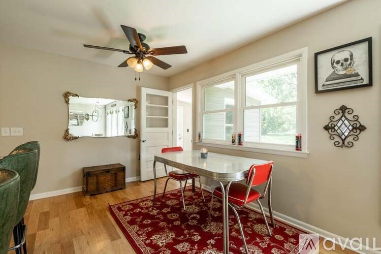 A dining room with a table and chairs.